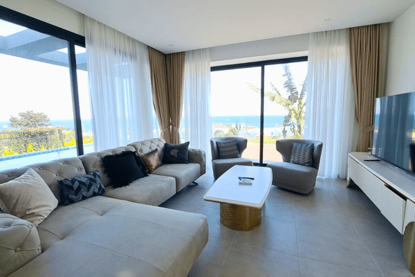 Living space with full-height windows offering light-drenched views and a soothing coastal atmosphere.