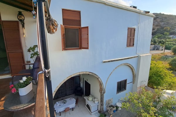 A beautiful stone-built estate offering traditional architecture, sea views, and a lush garden with a rustic outdoor oven.