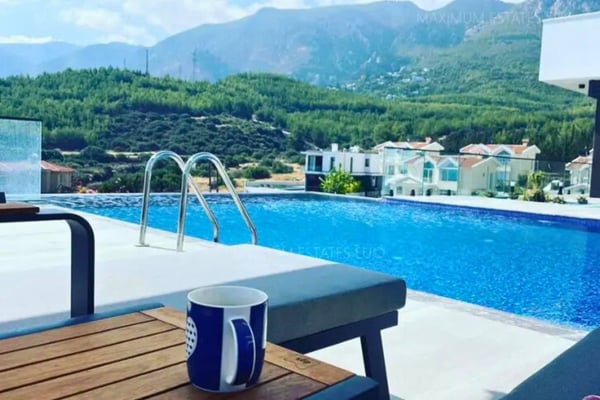 Mountain-view poolside setup with a scenic landscape and outdoor seating at a luxury estate.
