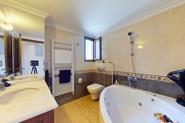 Luxurious bathroom with freestanding tub, double vanity, and frosted windows for light and privacy.