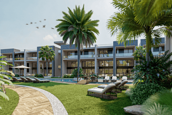 Lush green courtyard framed by contemporary buildings and palm trees, creating a relaxed and harmonious open-air space.