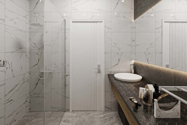 Premium finishes define this marble-clad bathroom with wall-hung WC and minimalist frameless shower for a sleek look.