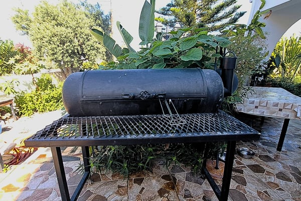 Close-up of a modern outdoor kitchen with a built-in grill, stone countertops, and ample prep space.