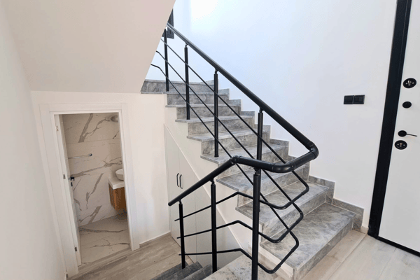 Upper stair landing with minimalist black-and-white railing design.
