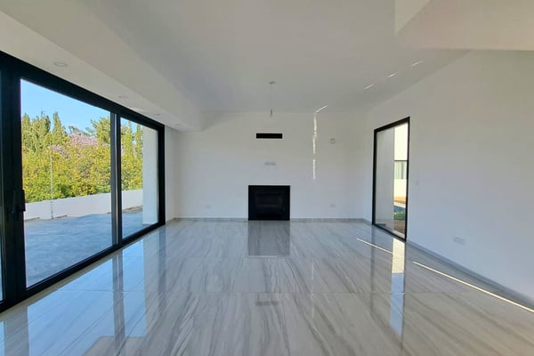 Living room with panoramic windows, glossy marble flooring, and an integrated fireplace, offering modern elegance and space.