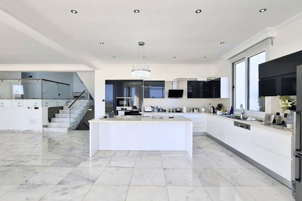 View toward kitchen and large refrigerator; glossy flooring.