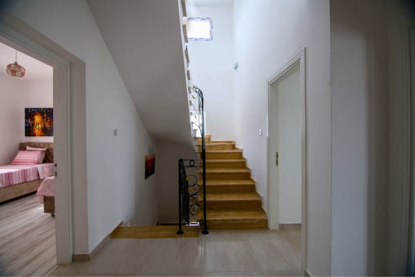 Interior staircase with wood flooring and sleek design connecting the villa’s spaces in stylish flow.
