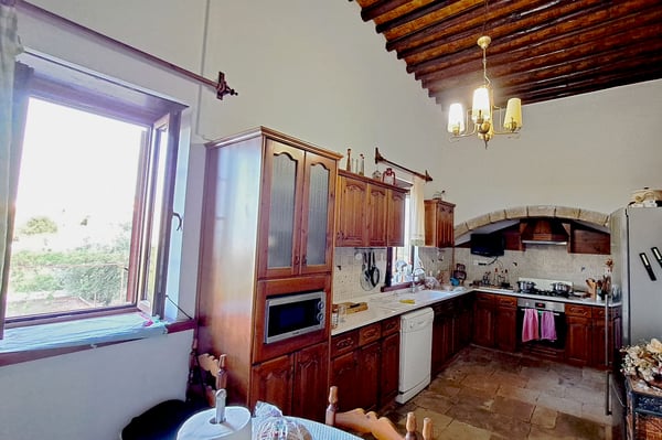 Covered Veranda with Wooden Ceiling – A spacious covered veranda with wooden beams, rustic furniture, and decorative wall elements.