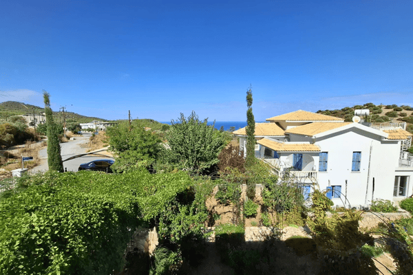 A wide landscape shot of the house nestled in the hills, emphasizing the natural surroundings.