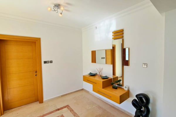 Mirror-lined hallway with built-in storage and ambient lighting, offering both function and stylish drama near the entrance.