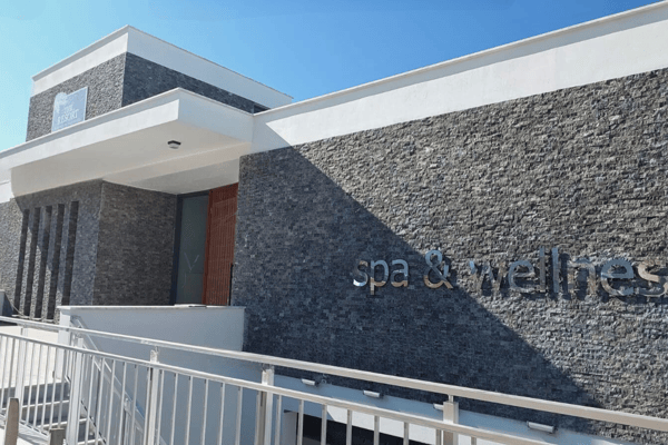 Dedicated spa and wellness center with modern stone exterior, promising luxury relaxation and a health-focused lifestyle.