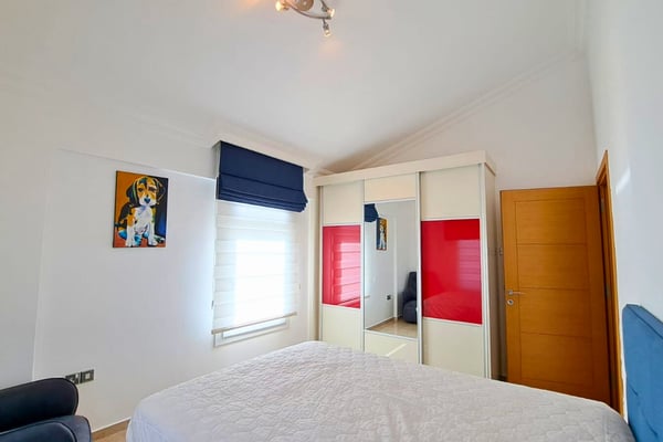 Second guest room with bold wardrobe accent, louvered shutters and playful tones for a balanced yet lively setting.