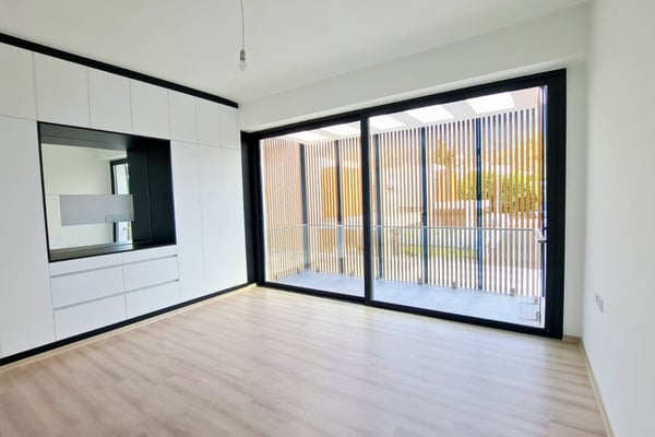 Additional room featuring balcony access, ideal as a guest space or home office, highlighted by soft lighting and finishes.