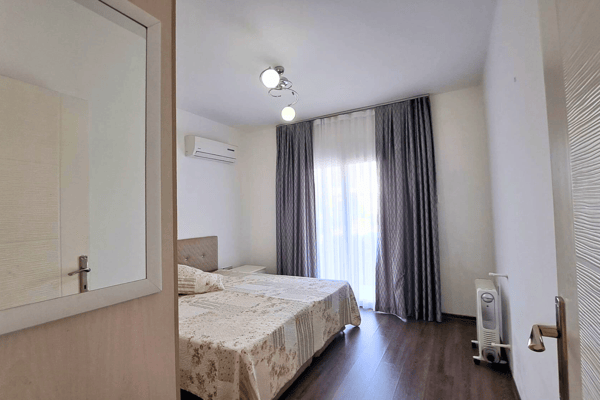 Third bedroom peeks through an open door, compact yet inviting, ideal for guests, study, or additional sleeping space.