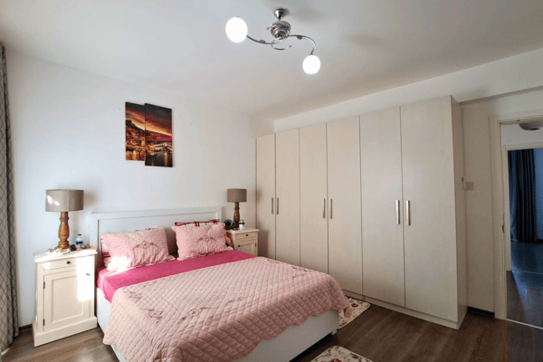 Master suite with full-wall built-in wardrobes and warm, neutral palette, maximizing storage without compromising style.