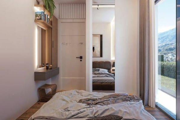 Peaceful bedroom with cozy seating, bright natural light, and minimalist styling perfect for unwinding.