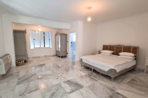 Neutral-toned bedroom with minimal furniture.