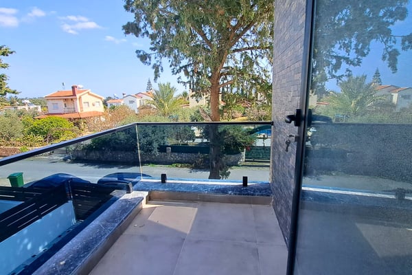 Poolside patio area directly adjoining indoor space via floor-to-ceiling windows.