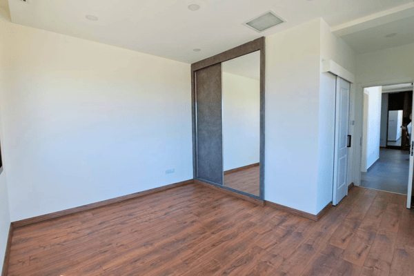 Hallway with soft tones and recessed lighting connecting the main living spaces.