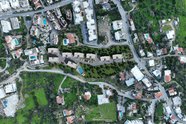 Satellite perspective revealing surrounding green areas and distant settlements, emphasizing the property's peaceful and natural setting.