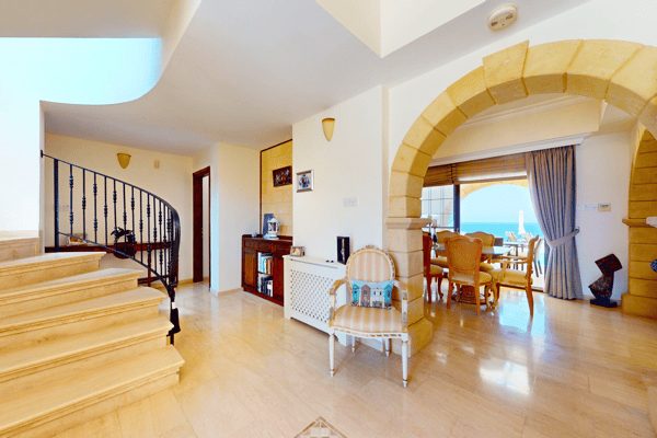 Main entrance with elegant staircase and warm tiled floors, welcoming with grandeur.