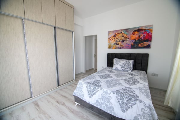 Inviting guest bedroom featuring harmonious design, soft color tones, and airy brightness.
