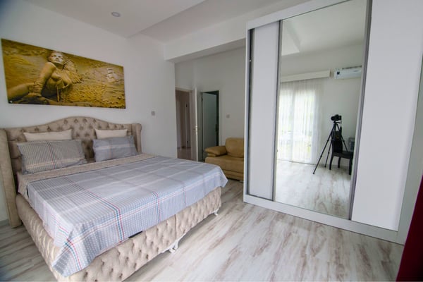Bright and inviting bedroom with modern decor and ample mirrored storage for elegant simplicity.