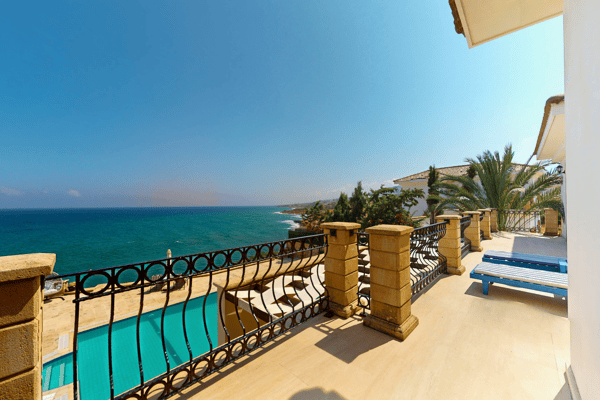 Second-level balcony with ornate railing and expansive Mediterranean outlook.