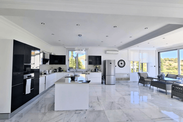 Modern black-and-white themed kitchen with island and sleek appliances.