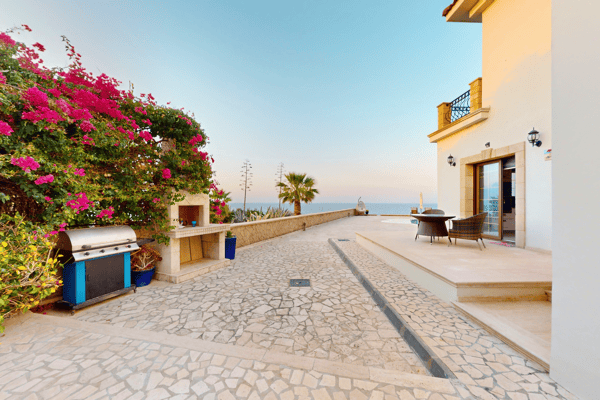 Side garden pathway leading through vibrant flora, highlighting the villa’s natural surroundings.