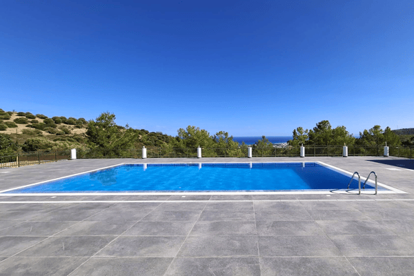 Clean poolside area with bright blue water and tiled flooring.