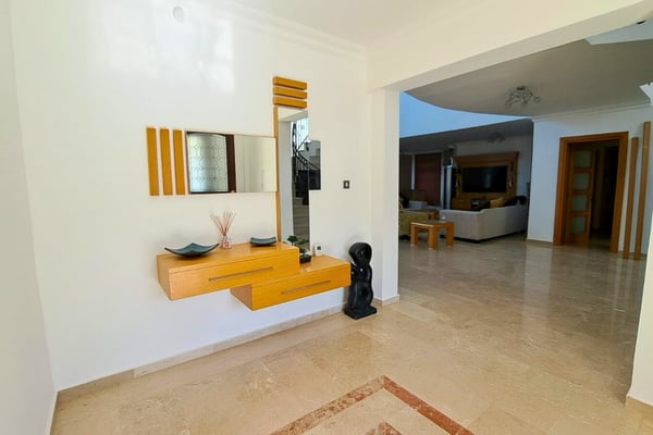 Entry vestibule with oak door and floating console, giving a clean, modern first impression with sleek surfaces.