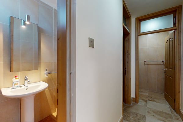 Contemporary hallway featuring wooden flooring, large windows, and minimalist decor leading to different sections of the villa.