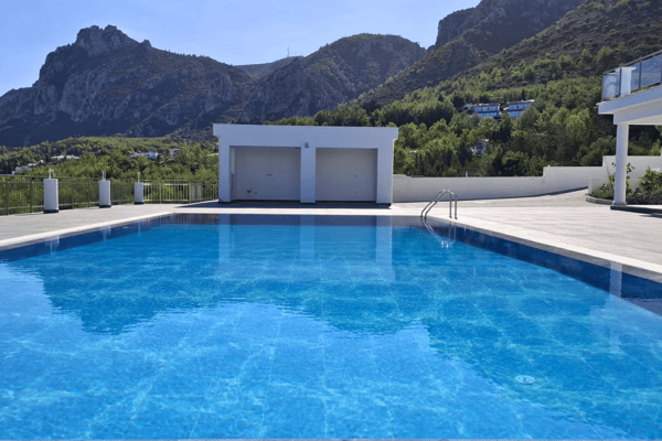 Pool close-up showing turquoise water, submerged steps, and part of the villa.