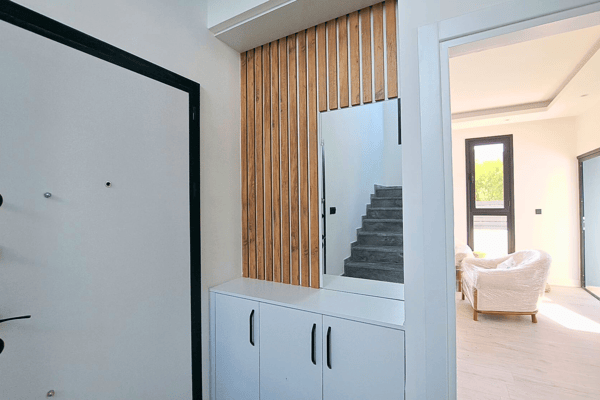 Hallway storage area with vertical wood panel detail and sleek cabinetry.