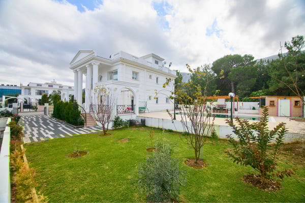 Side profile of the villa displaying lush gardens and well-kept grounds designed for visual harmony and calm.