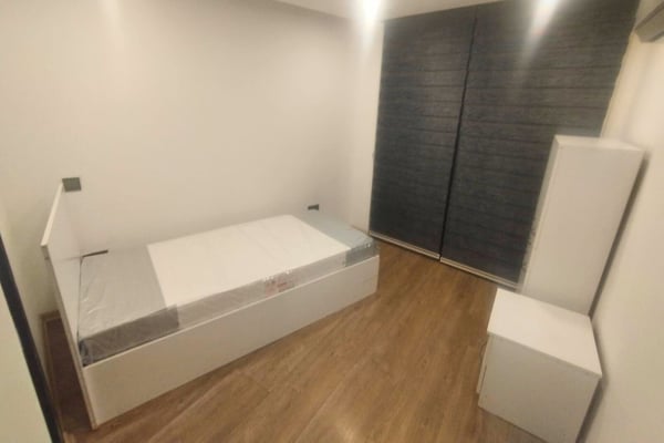 Minimalist guest room or second bedroom with consistent design tones and ample natural light for a soothing ambiance.