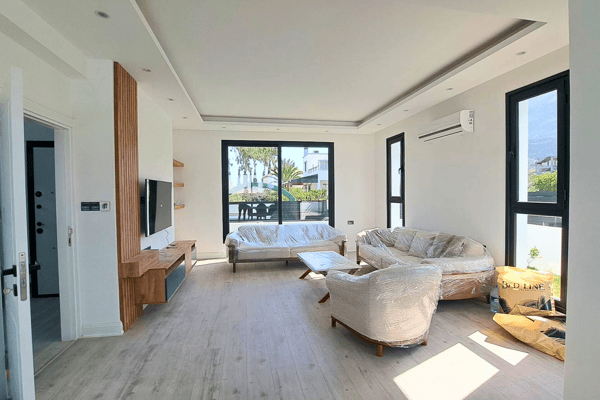 Living room facing the garden and pool, with soft furnishings and neutral tones.