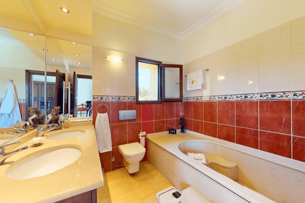 Another full bathroom with red and cream tiling, creating a cozy yet modern feel.