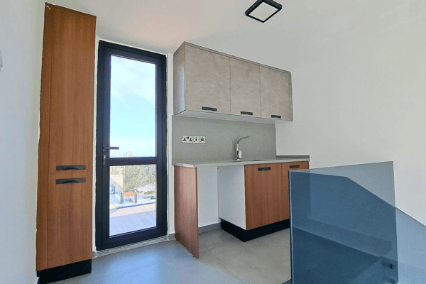 Functional utility kitchen with exterior access and sleek cabinetry details.