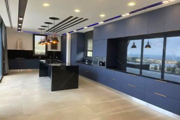 Spacious open-concept luxury kitchen with minimalist design and floor-to-ceiling windows.