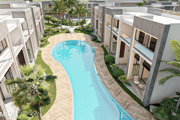 Curving communal pool with a natural layout flowing beside private terraces and bordered by tropical plants and seating.