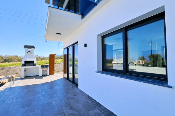 Terrace with glass railing and automatic serving window, linking indoor kitchen to outdoor bar.