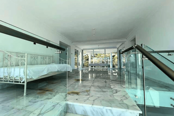 Sun-room or indoor pool room with wide tiles and windows.