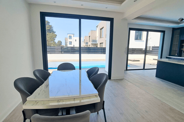 Dining table set next to sliding door, offering a sunlit breakfast nook.