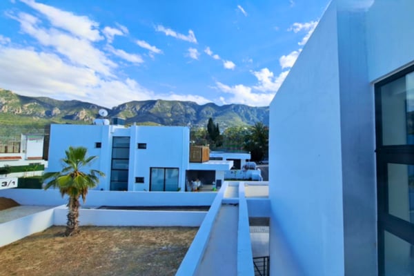 Elevated view showing villa’s proximity to upscale homes with scenic mountain views, emphasizing suburban luxury and setting.