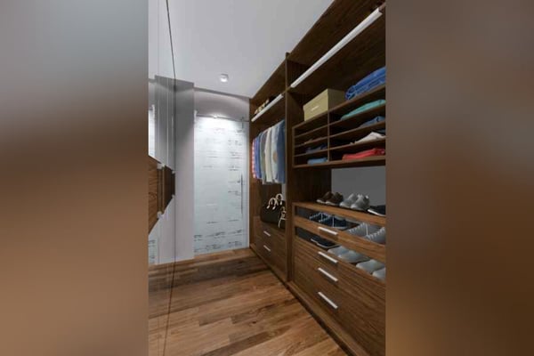 Luxurious walk-in closet with wooden finishes, ample storage space, and soft lighting