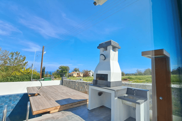 Rooftop terrace showing built-in BBQ area with chimney and scenic views.