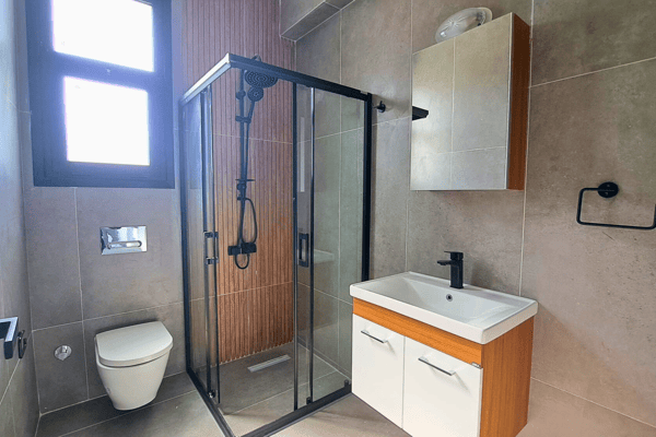 Guest WC with compact design, window ventilation, and minimalist vanity.