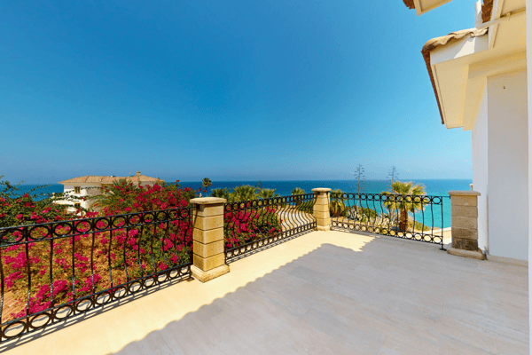 Flower-decorated balcony rail with dramatic sea backdrop—romantic and peaceful.